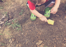 a toddler playing in dirt 