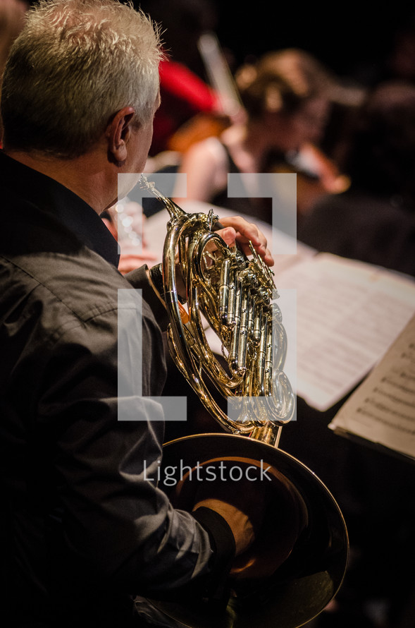 man playing a French horn 