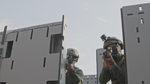 Soldiers training in close quarters combat with automatic rifles