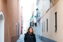 woman walking down a narrow street 