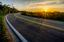 sunburst over rural road 