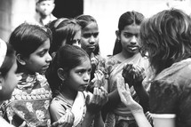 Woman and girl children in prayer on a mission trip 