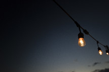 hanging lightbulbs outdoors at night 