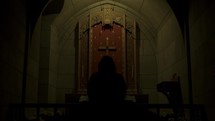 woman praying along in a church 