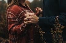 a couple holding hands outdoors in fall 