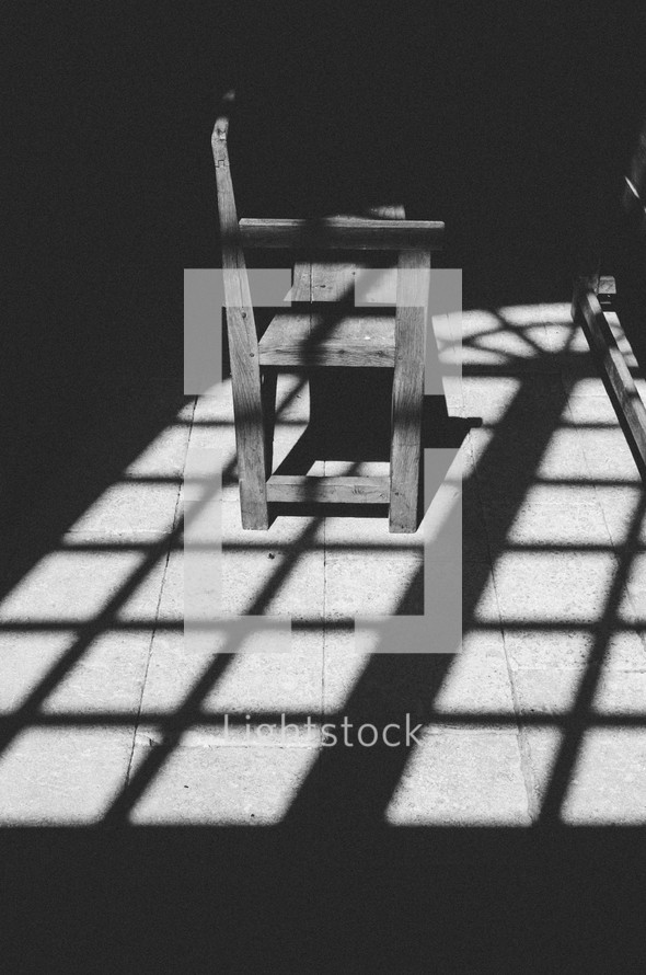 shadows and sunlight on a bench under a pergola 
