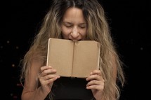 Girl biting a book.