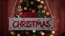 Merry Christmas sign decoration with blurred Christmas tree 