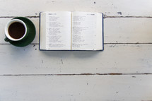 coffee cup and open Bible on a wood table 