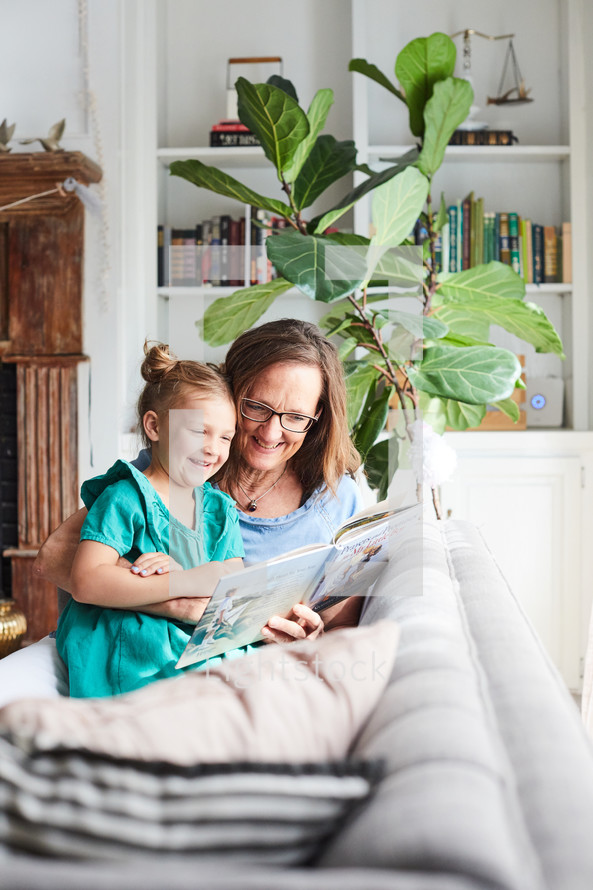 grandmother reading a book to her granddaughter 