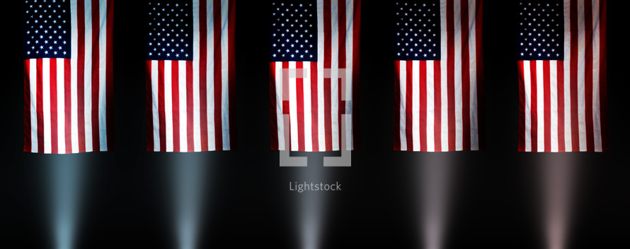 rows of American flags illuminated by spotlights 
