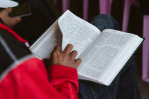 person reading a Bible during a worship service 