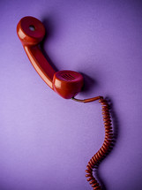 red rotary phone on purple background 