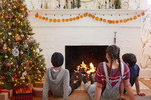 kids relaxing in front of a fire at Christmas 