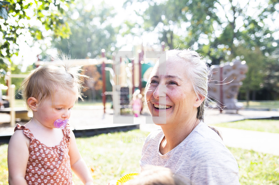 Smiling woman with toddler at playground