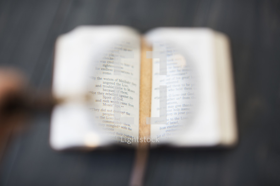 magnifying glass on the pages of a Bible 