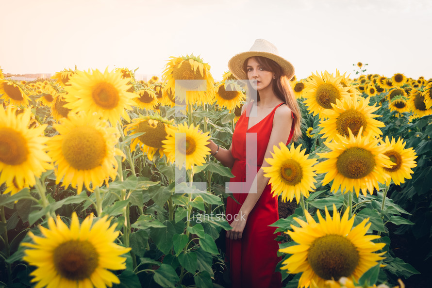 woman with red dress in sunflower field.