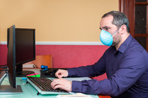 man with medical mask working in house. Teleworking concept