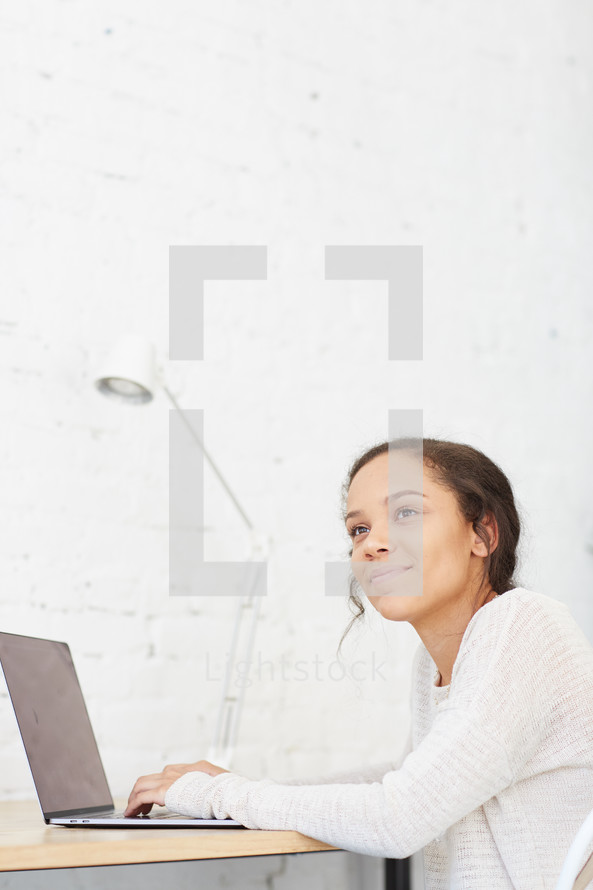 woman sitting at a desk with a laptop computer 