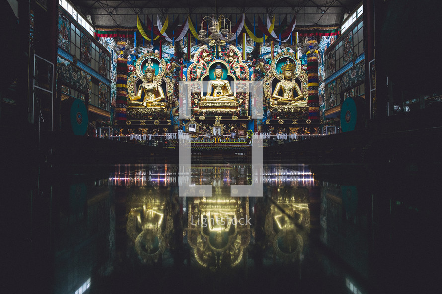 Golden statues inside of a Buddhist temple. 
