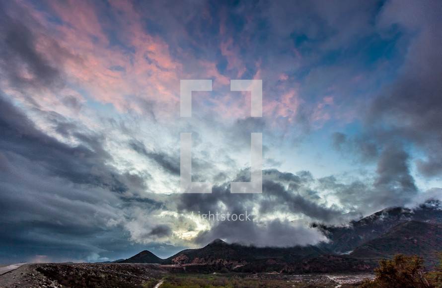 clouds above mountain peaks at sunset 