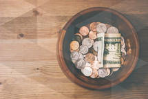coins and cash in a bowl 