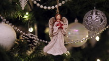 Angel ornament with red star on a Christmas tree
