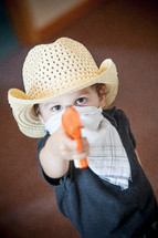 toddler pointing a toy gun 