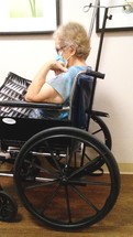 An elderly woman with white hair in a wheelchair wearing a face mask awaiting help from a Doctor or Nurse at a hospital. The year of Covid-19 has taken its toll on nursing homes across the country as CNA's, Nurses and health care professionals get sick from COVID-19 and endanger the lives of the elderly causing shutdowns, isolation, loneliness and separation from loved ones as well as a devastation to the United States Economy. While sickness, fear, poverty make headline news, people forget that the Lord is still in control over their lives, their wealth, their health and their eternal reward in Heaven. COVID-19 may be the buzzword for the year 2020 but it is not the final word on our future as Christ holds the future in His hands, even when we are old and gray.

