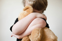 child hugging a teddy bear 