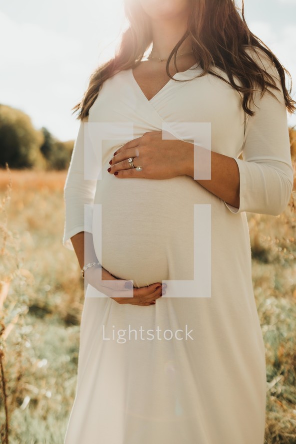 a pregnant woman with her hands on her belly 
