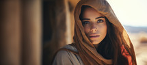 Close-up portrait of a young woman with a headscarf. Desert landscape in the background
