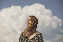 young woman alone in front of huge cloud bank