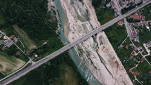 aerial view over traffic crossing a bridge over a river 