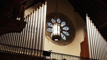 Looking up at a church lantern with stained glass windows in the background.