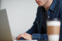 a man thinking sitting behind a computer 