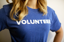 A woman wearing a blue t-shirt reading, "volunteer."