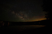 Milky Way stars rising over a small lake