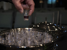 A man taking a communion cup from a tray