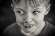child touching his tongue to his nose