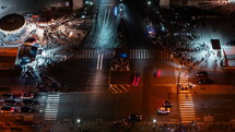 Traffic and pedestrians crossing a busy intersection in Paris at night, timelapse
