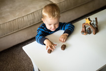 a toddler playing with a wooden nativity 
