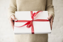 a woman holding a wrapped Christmas gift 