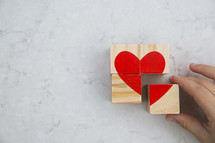building a heart out of wood blocks 
