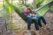 a couple snuggling in a hammock 