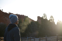 a man in a sweatshirt and beanie taking in a view 