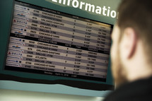 man looking at flight information at the airport 