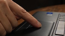 Close up of a woman using a touch pad on a notebook computer