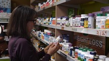 A woman shopping for vitamins in a health food store