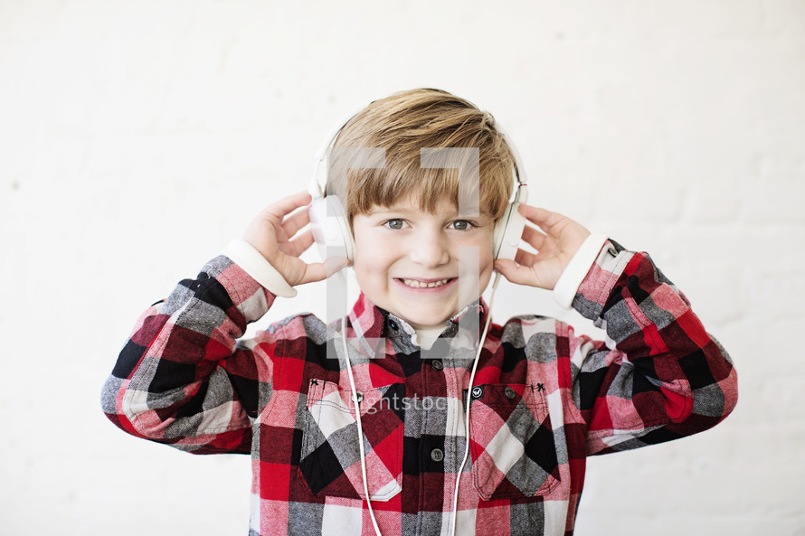a boy child wearing headphones and smiling
